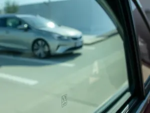 Samochód na podnośniku w jasnym, samoobsługowym warsztacie z kącikiem wulkanizacyjnym i podstawowymi narzędziami.