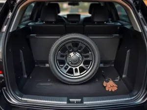 Srebrny Peugeot 206 z obniżonym zawieszeniem i sportowym body kitem, podkreślającym tuning nadwozia na ulicy miejskiej.